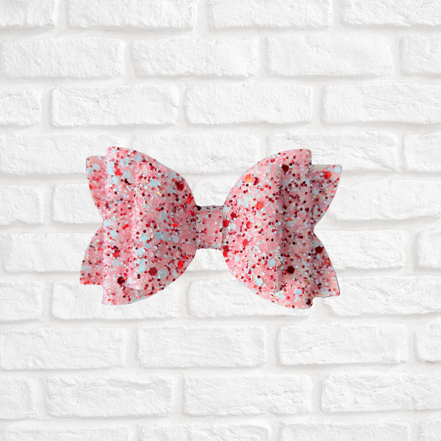 Pink and white floral bow on a white brick wall background