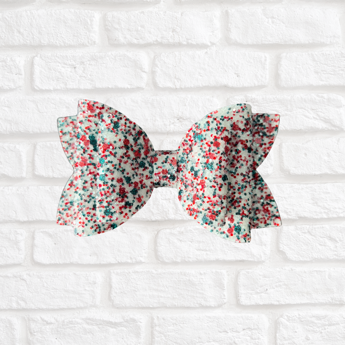 Floral-patterned bow on a white brick background