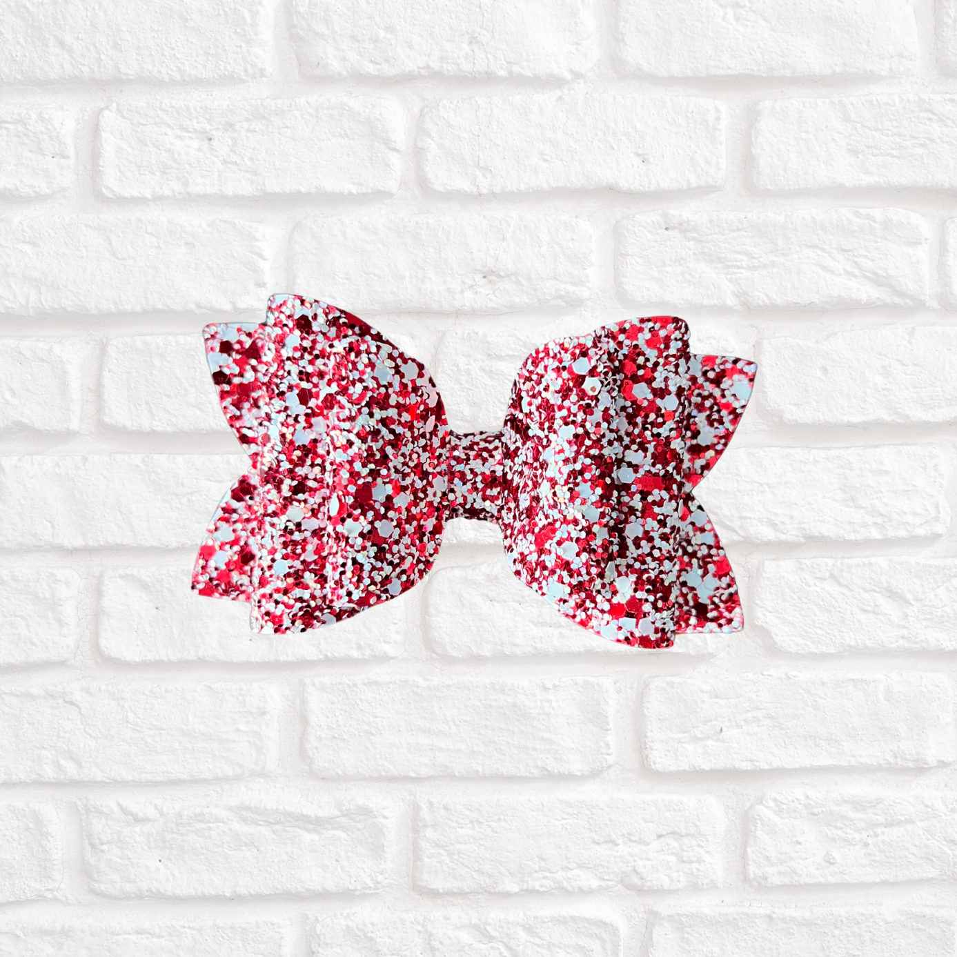 Red and white floral bow on a white brick background